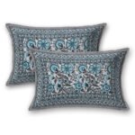 Two rectangular pillows on a gray background covered with a matching Jaipuri pure cotton bedsheet set, showcasing traditional turquoise floral patterns with a black and white border.