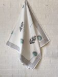 . A set of three towels, including one bath towel and two hand towels, featuring white fabric with delicate blue and green flower designs.