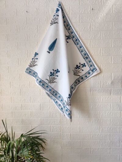 A white and blue bath towel gracefully draped on a wall.