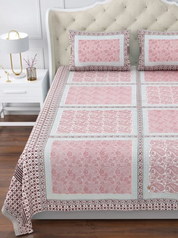 A king size Pink and white bedspread with a beautiful floral pattern, spread nicely on bed.