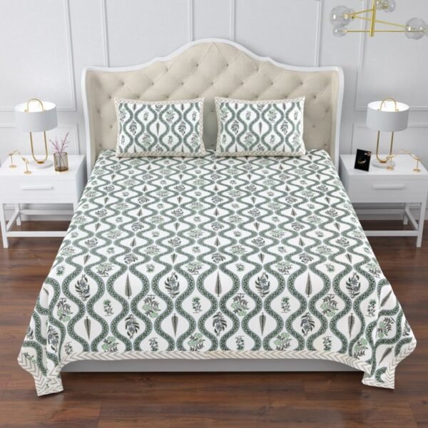 A king size bed covered in a green and white King size bedsheet bedspread with a jaal print and floral patterns.