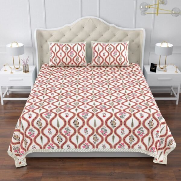 A king size bed with a red and white bedspread featuring a jaal print and floral patterns.