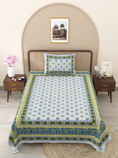 A single bed with a blue and yellow bedspread, accompanied by a matching pillow cover.