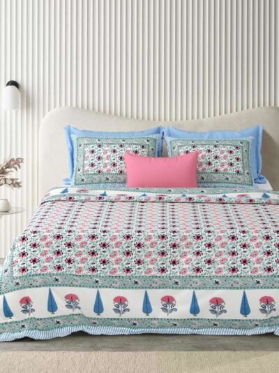 a bed with a floral comforter and pillows