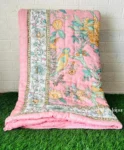 a pink pillow and blanket on a green grass floor