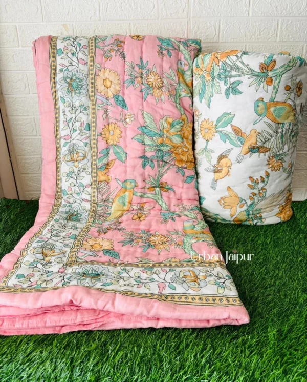 a pink blanket and pillow on grass